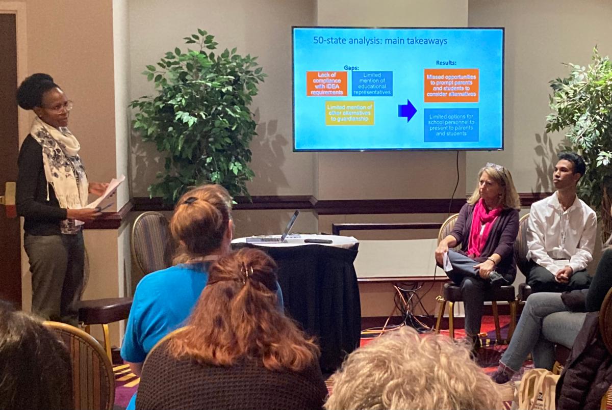 Two people presenting by a screen