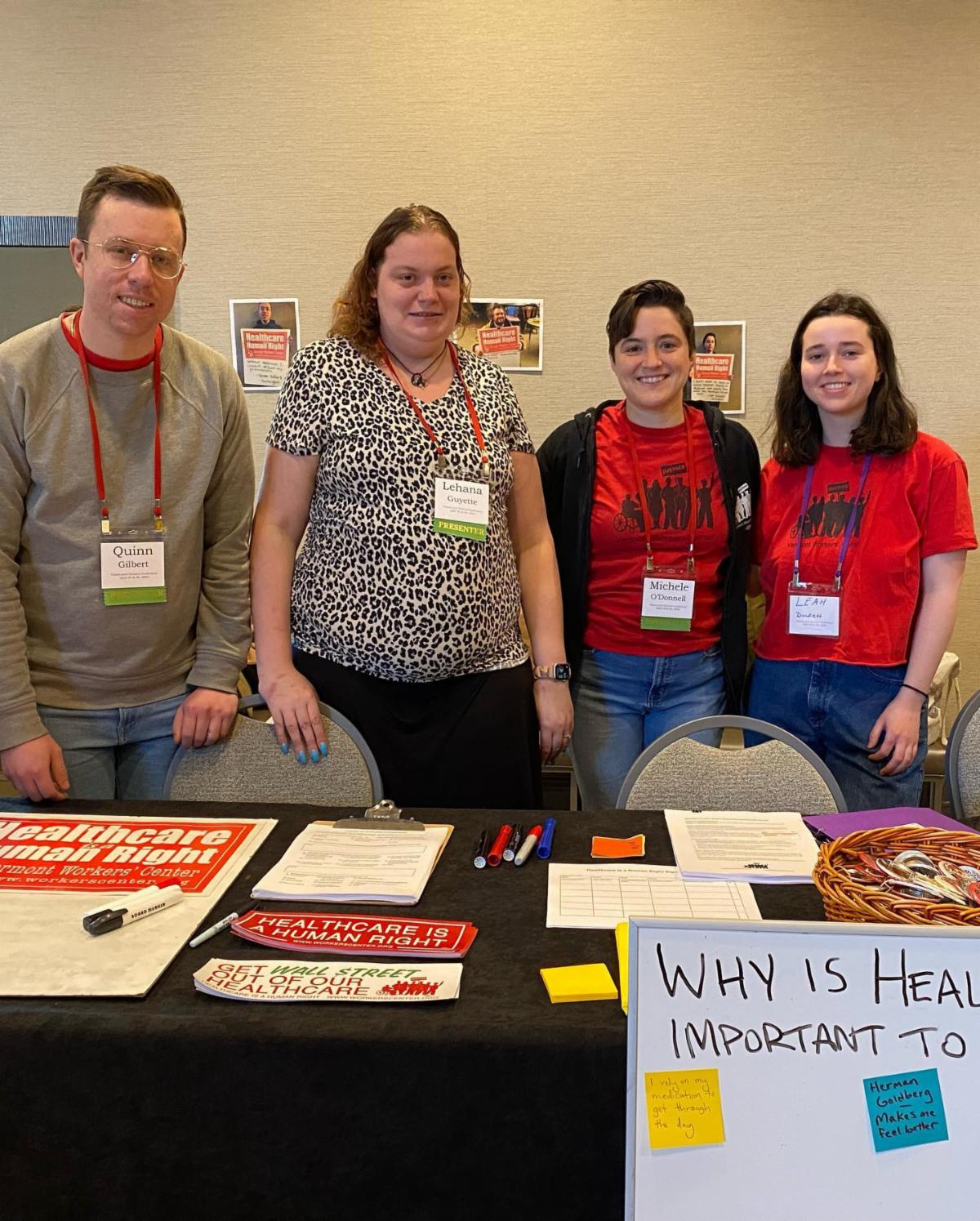 Group photo of four people standing at a table