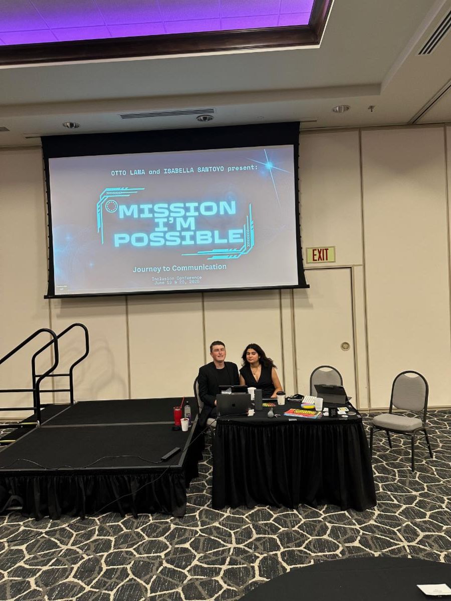 A young person in a gray suit white shirt and striped tie speaks into a microphone while testifying before the Texas House Committee on Higher Education. The text overlay on the screen reads COMMITTEE ON HIGHER EDUCATION and HB 2081 along with the seal of 