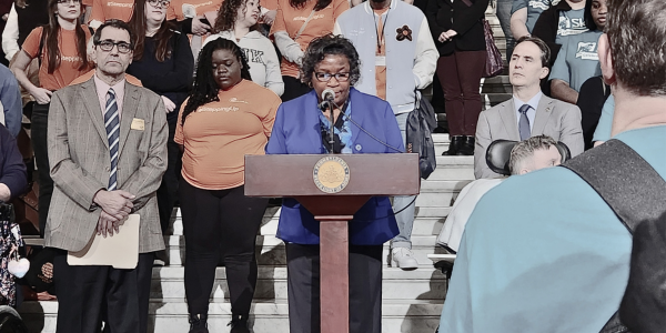 a photo of an advocate speaking at a podium
