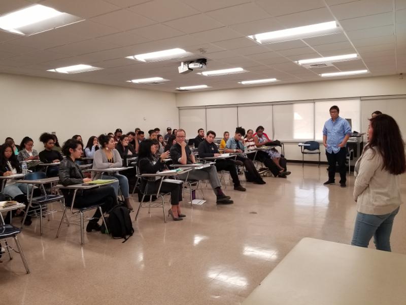 students presenting in a classroom. Students sitting in a classroom listening to students 