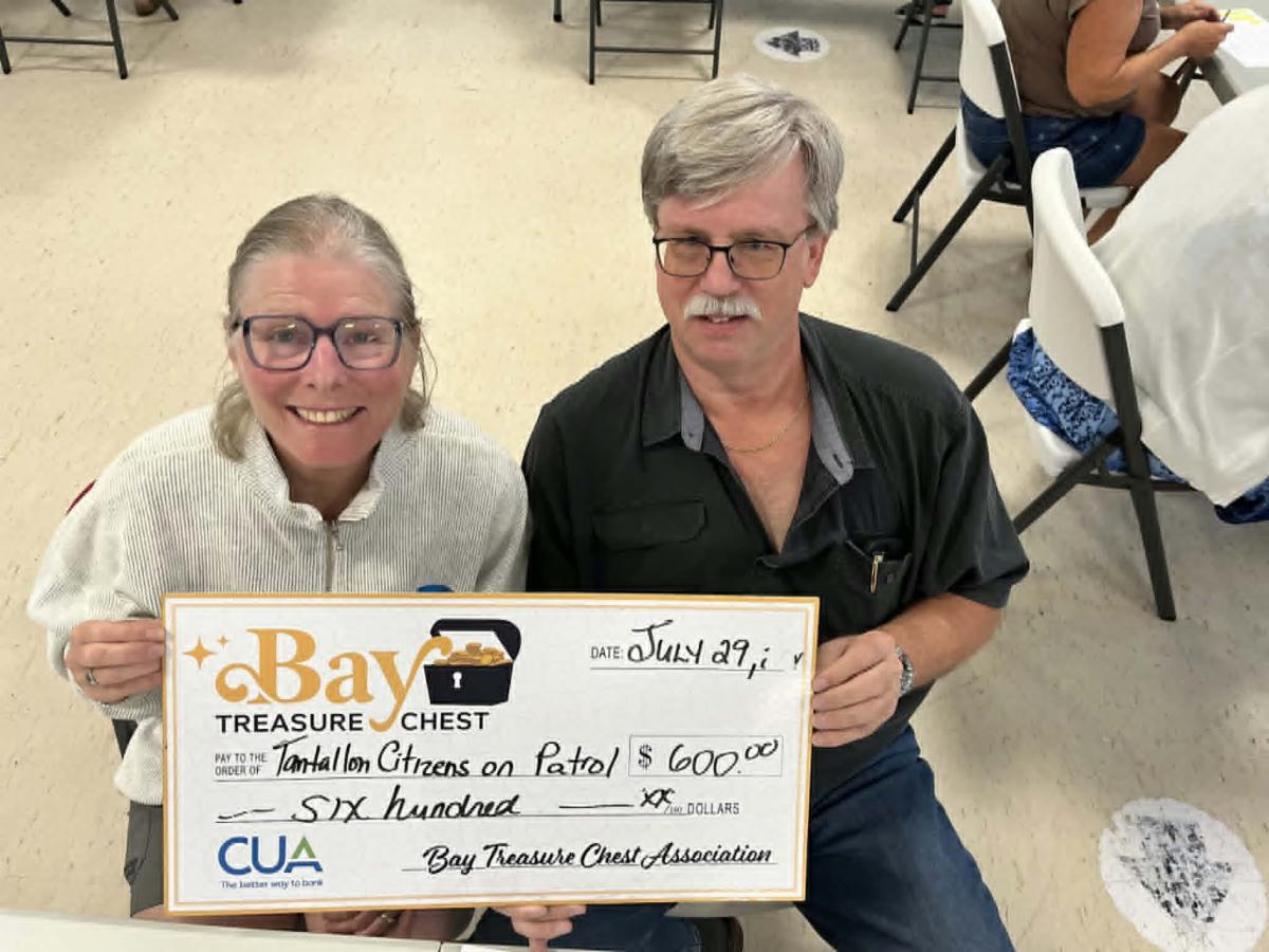 volunteer count team - a woman and a man - holding an oversized honorarium cheque