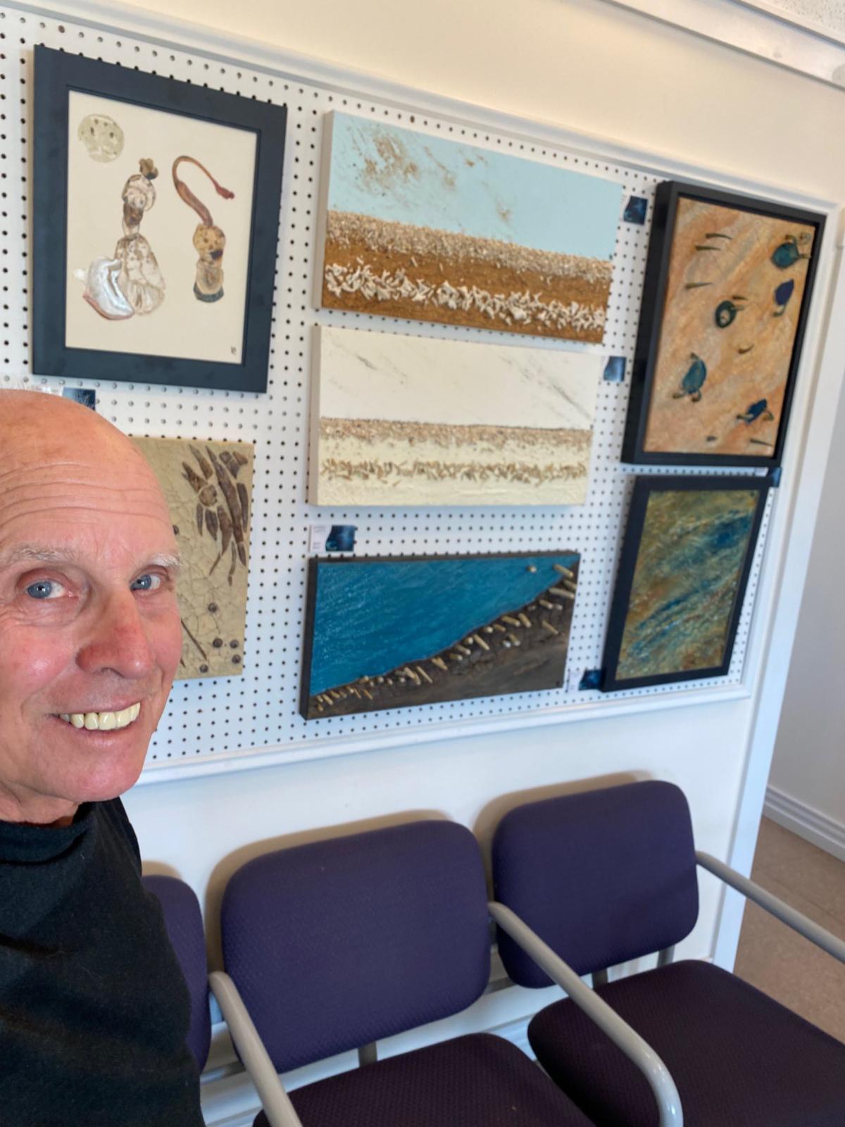 PCAAS artist in front of some of his art