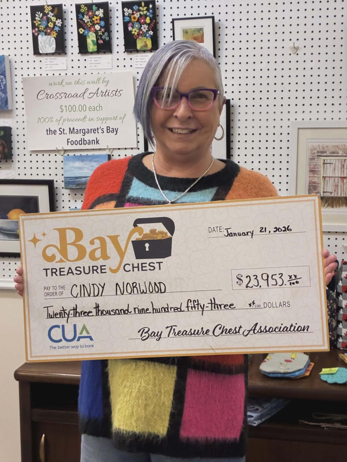 BTC winner woman in colourful top holding oversized cheque