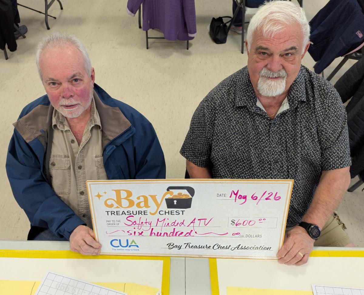volunteers holding an oversized honorarium cheque