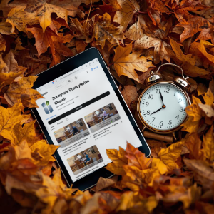 Photo of an alarm clock and iPad in a bed of fall leaves with the SVPC YouTube page showing on the iPad