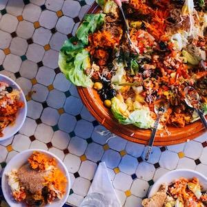 Stock photo of a taco salad bowl and side dishes on a table