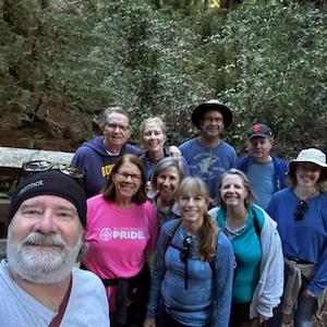 Group photo after a recent hike showing ten people in front of a lot of trees