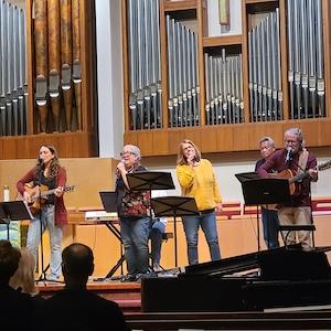 Photo of the Modern Worship Collective band singing at the front of the sanctuary