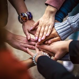Stock photo of multicultural hands reaching into the center of the circle in a symbol of teamwork