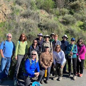 Group of hikers in front of a grassy hillside