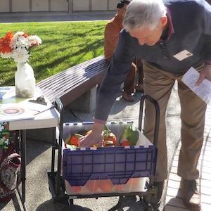 photo of a man bending over to choose oranges out of a bin