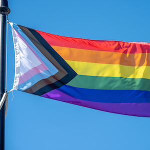 Quasar progress pride flag flying against a blue sky