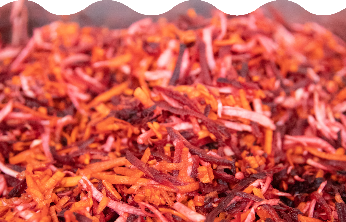 a bowl of magenta root slaw with shredded carrots and beets and parsnip
