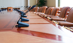 Empty office chairs with a line of microphones in front of them