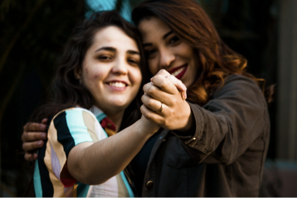 Female teen with a disability dancing with an older hispanic woman