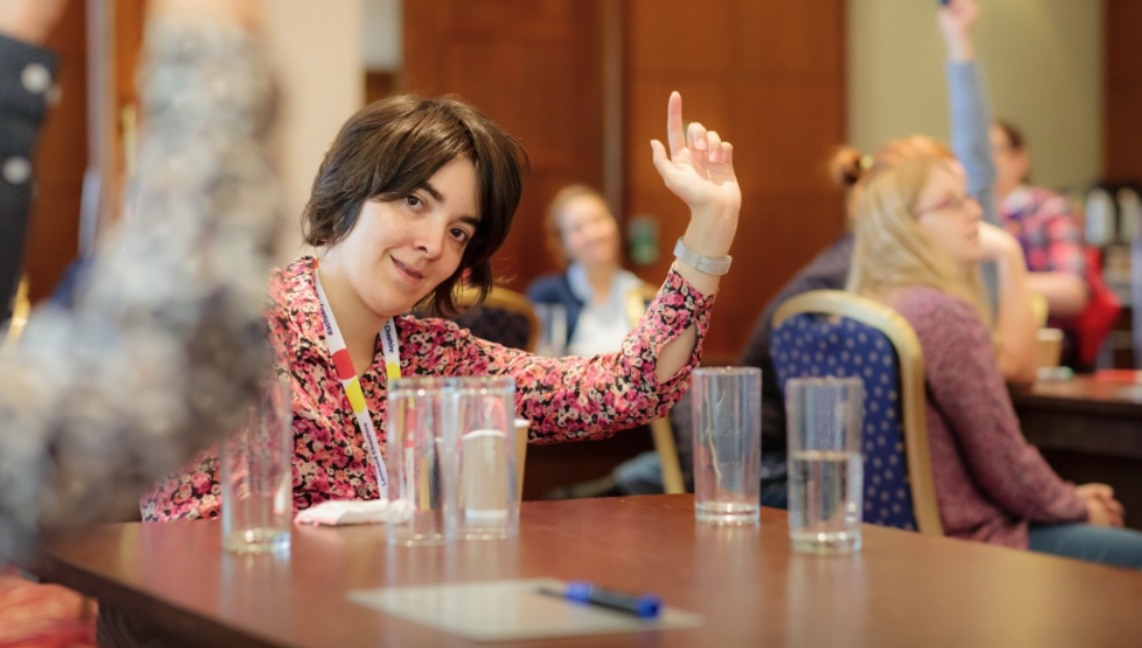 The author of the post raising her hand at a live meeting