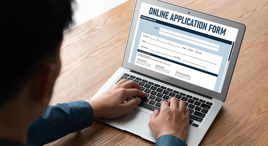 Young man working on an online job application on a laptop