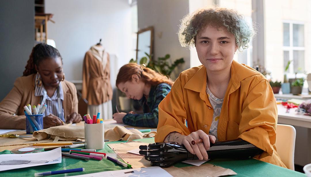 Young adult female with a prosthetic forearm and hand working in an art studio 