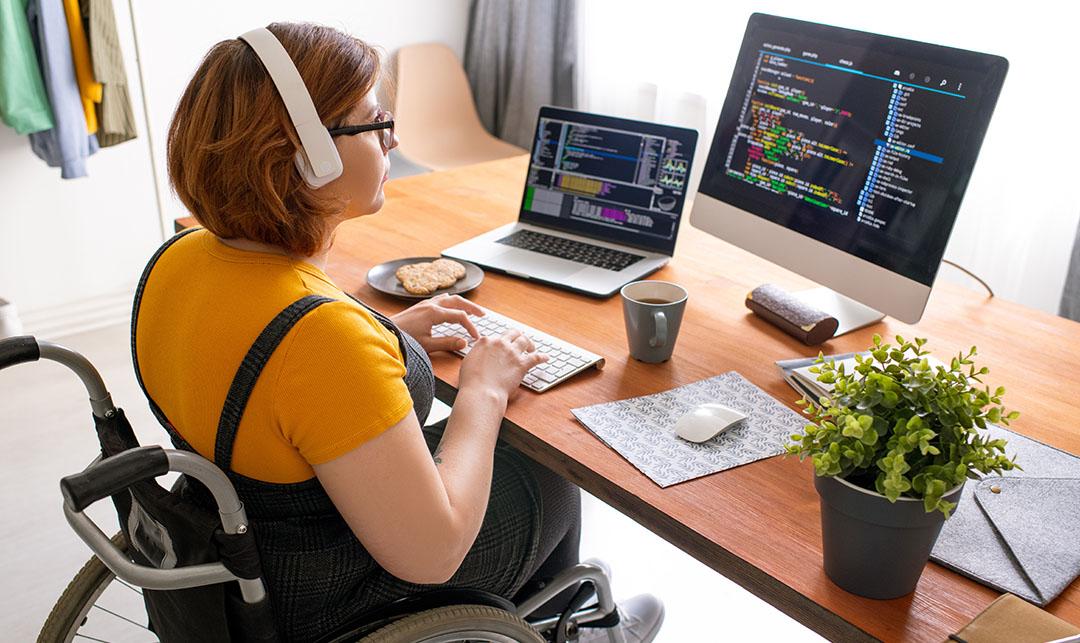 woman with a disability working on coding project remotely at her home