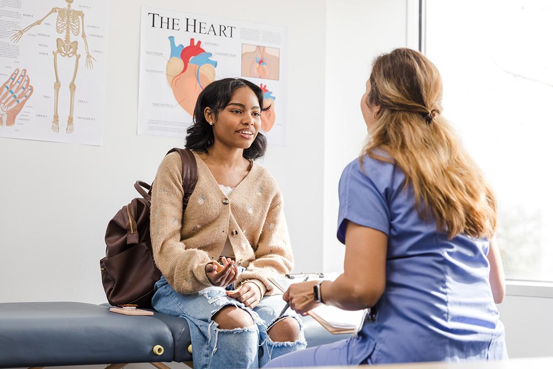 Femal teen meeting with and talking to a female medical doctor