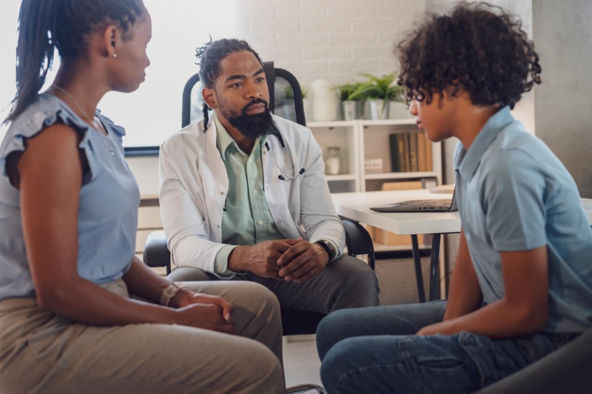 African Ameriican counseler working with a pair of young adults in therapy