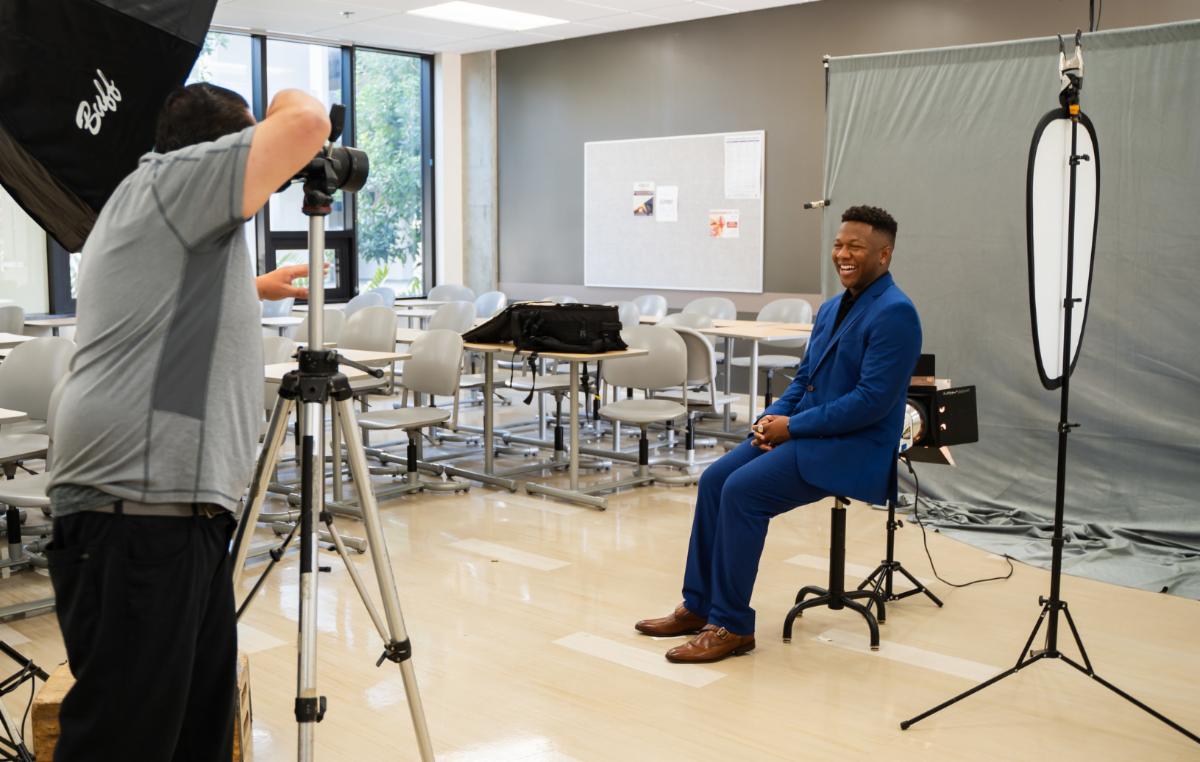 Student Angel Wilson has a headshot taken by a professional photographer during a career fair.