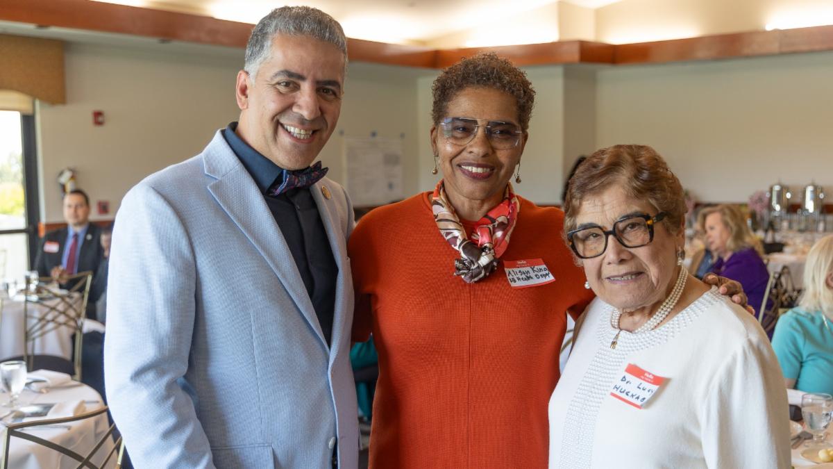 three people pose for a photo