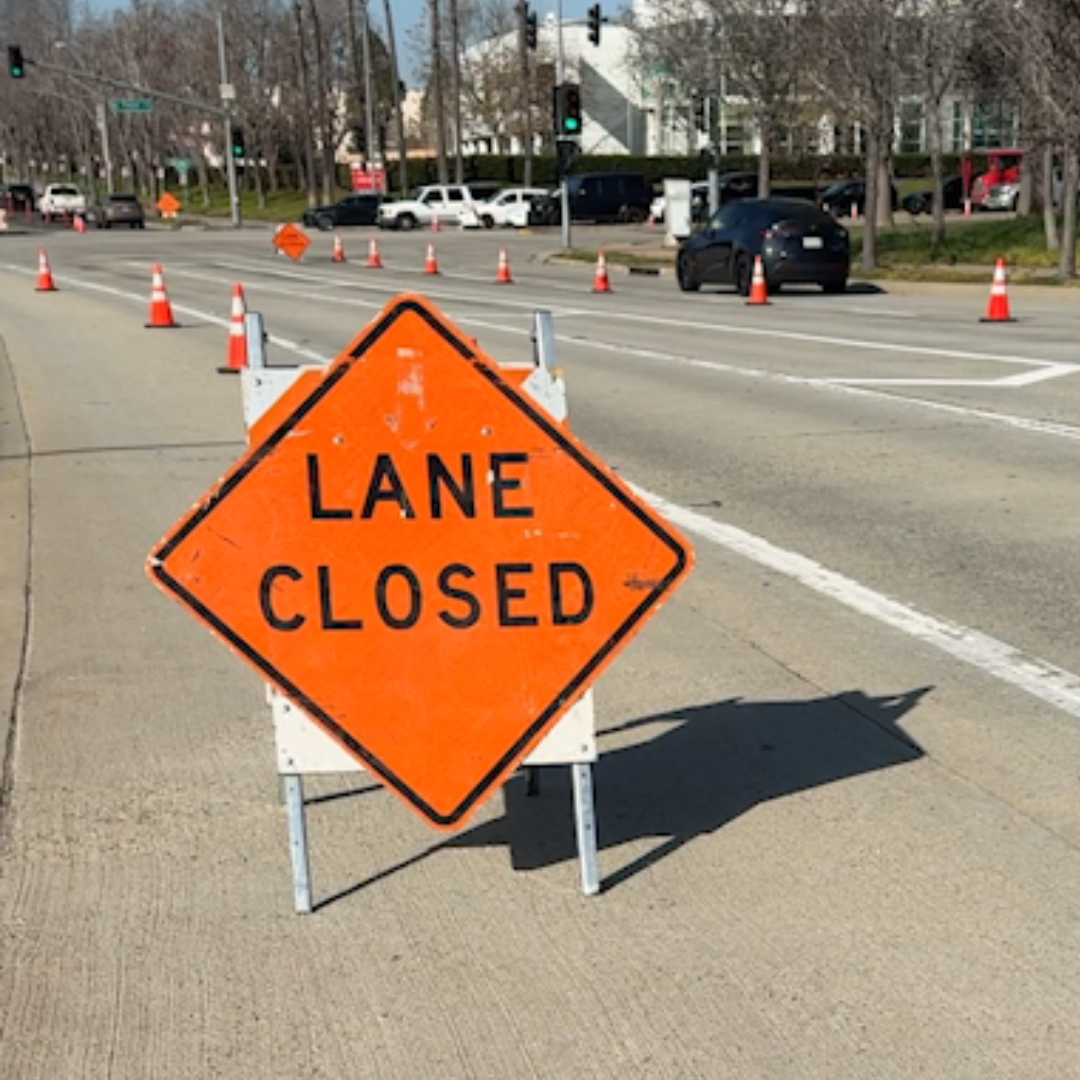 A Lane Closed sign stands in the street.