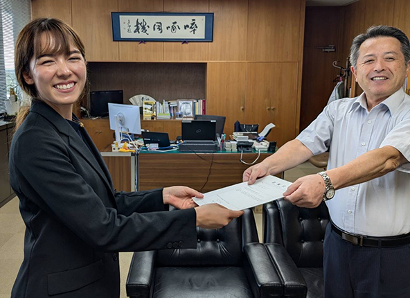Yuko Wilson receives her letter of appointment from Toru Tamaki