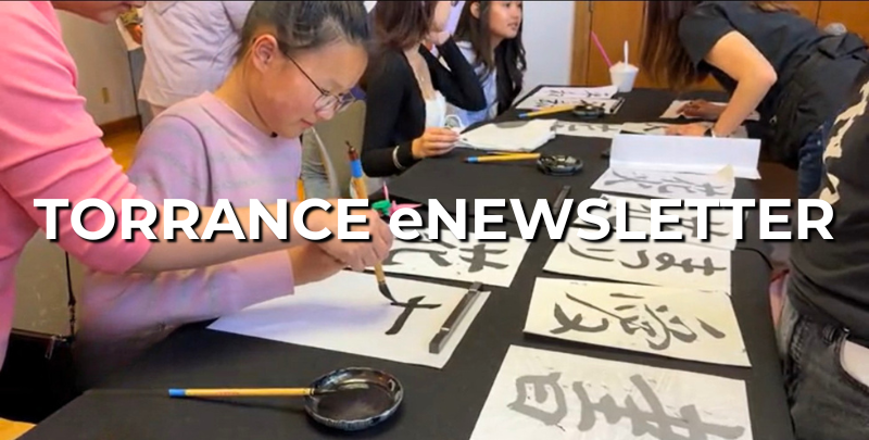 young child writing calligraphy with brush and black ink
