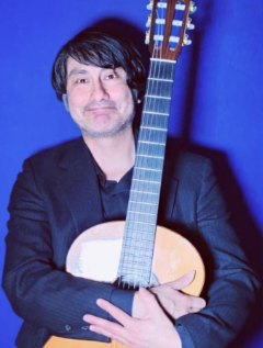 A picture of Giovanni Guillen holding a classical guitar.