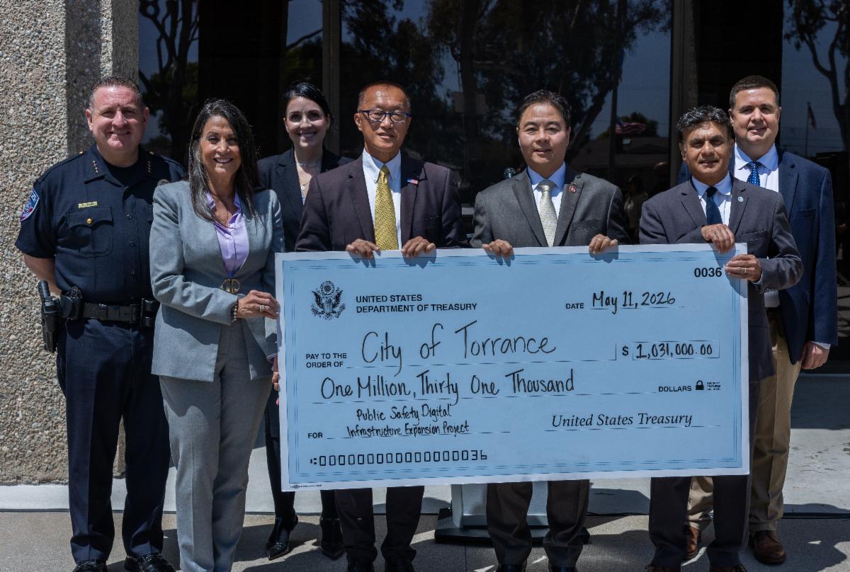 Group of city officials and elected officials holding a large Check