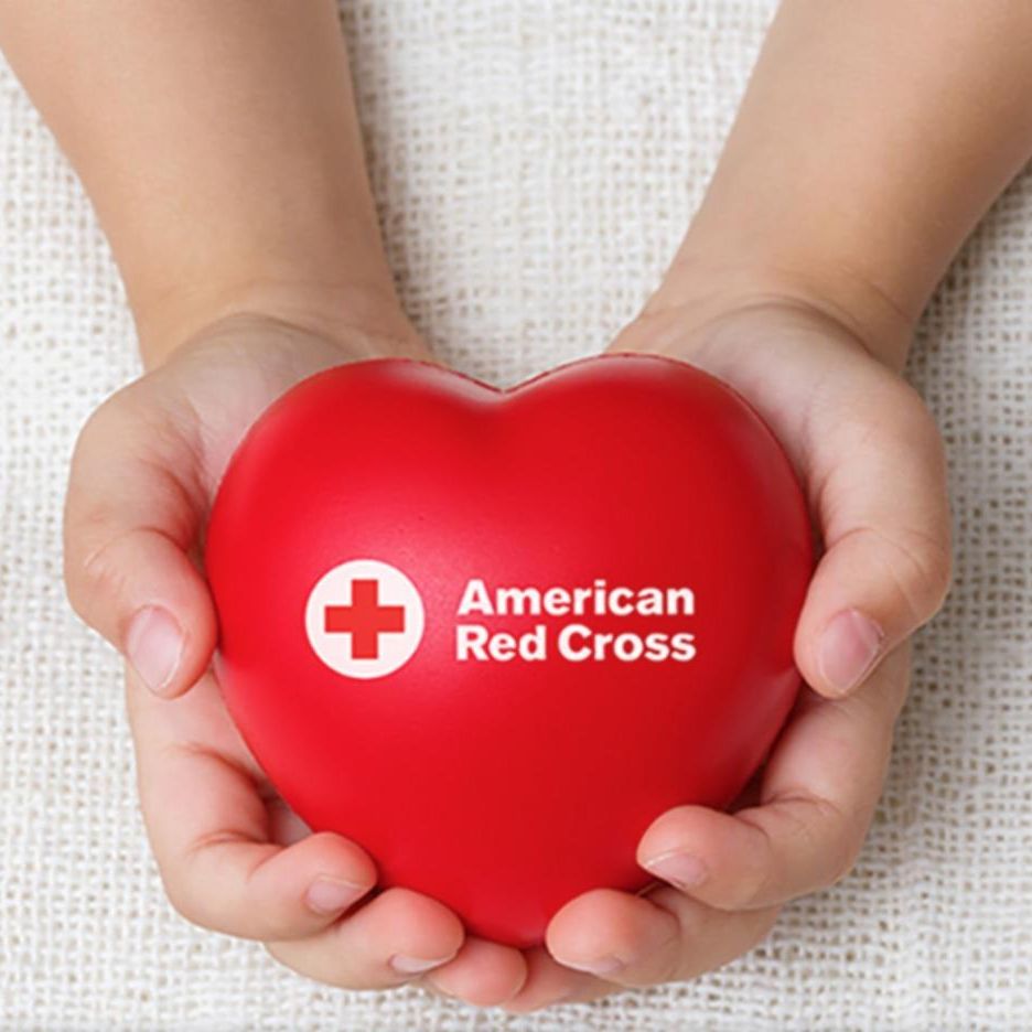 A red heart shape displayed within a American Red Cross promotional graphic to sign up to donate blood 