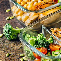 lunch containers with broccoli, tomato, chickpeas, and chicken