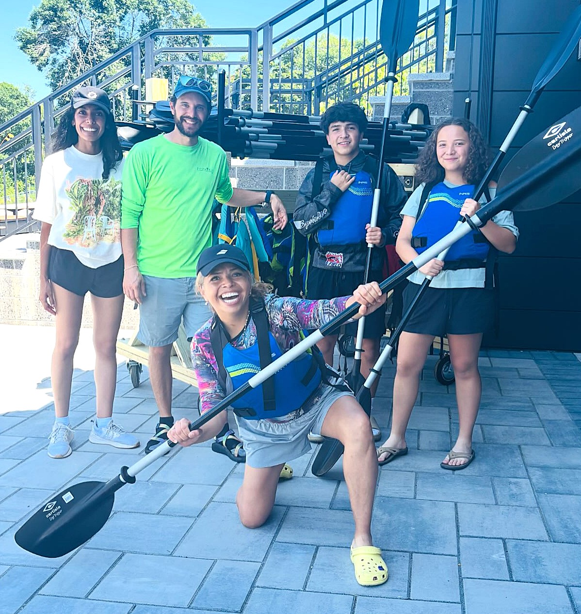 A family holds paddles as they get ready for a kayak adventure