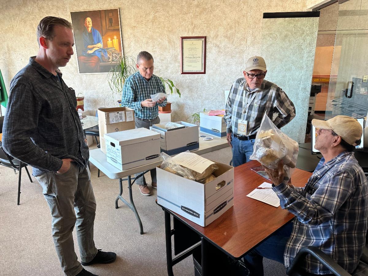 Dr. Devin Pettigrew with INAH Chihuahua colleagues looking through boxes of returned artifacts. 