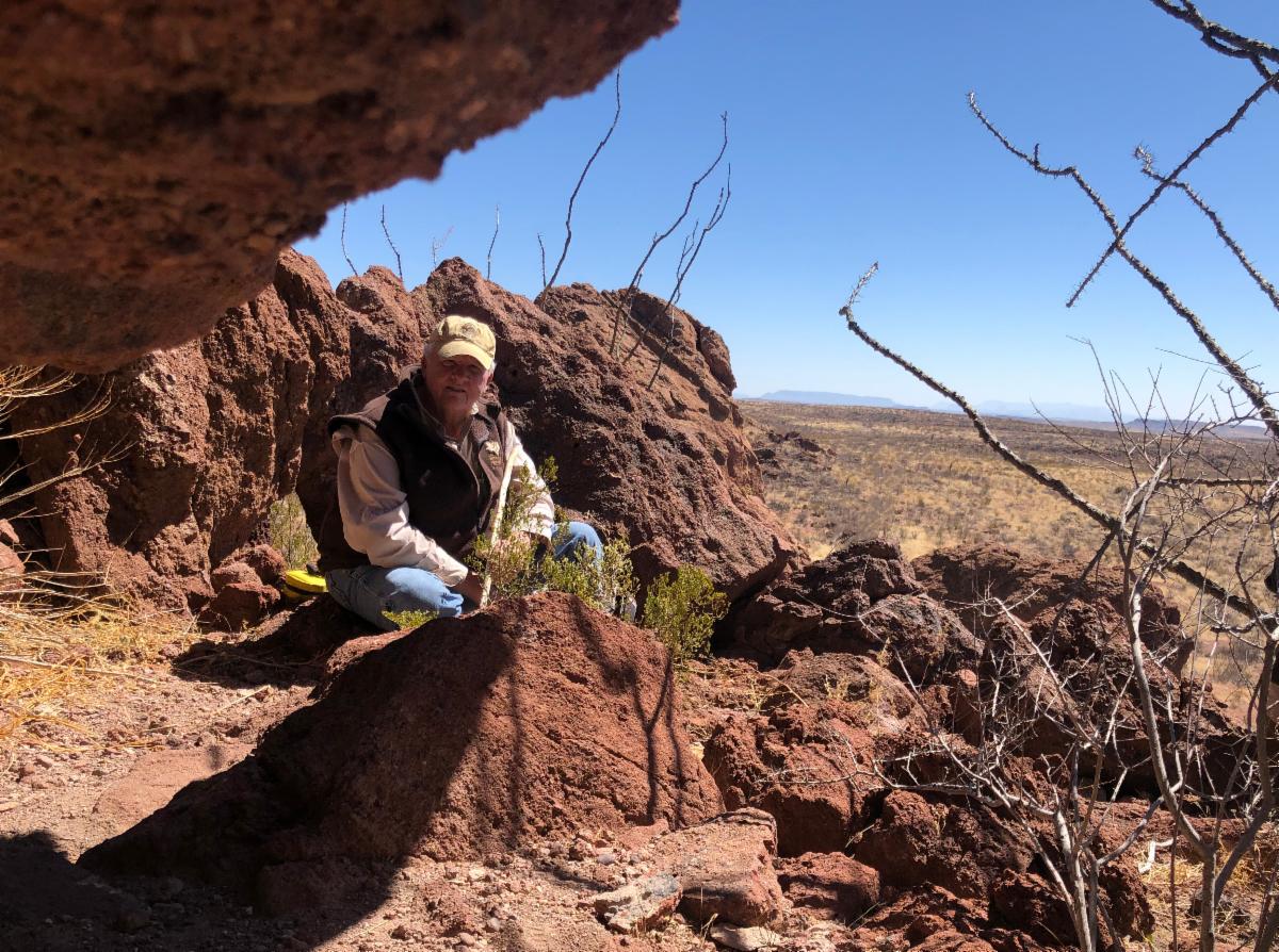 Homer Mills looking into a rockshelter. 