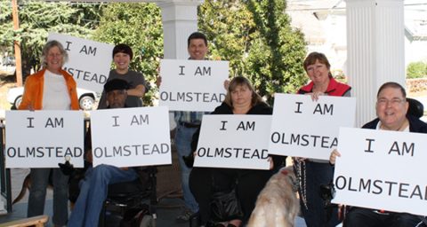 A group of people holding signs that say "I AM OLMSTEAD".