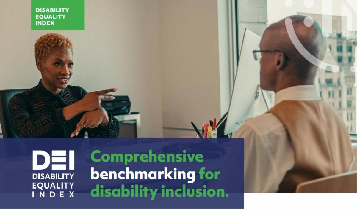 Black woman in office signing to coworker Disability Equality Index logo Comprehensive benchmark for disability inclusion