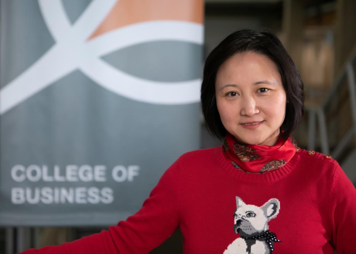 dean zhao, red sweater, puppy  on front- smiling 