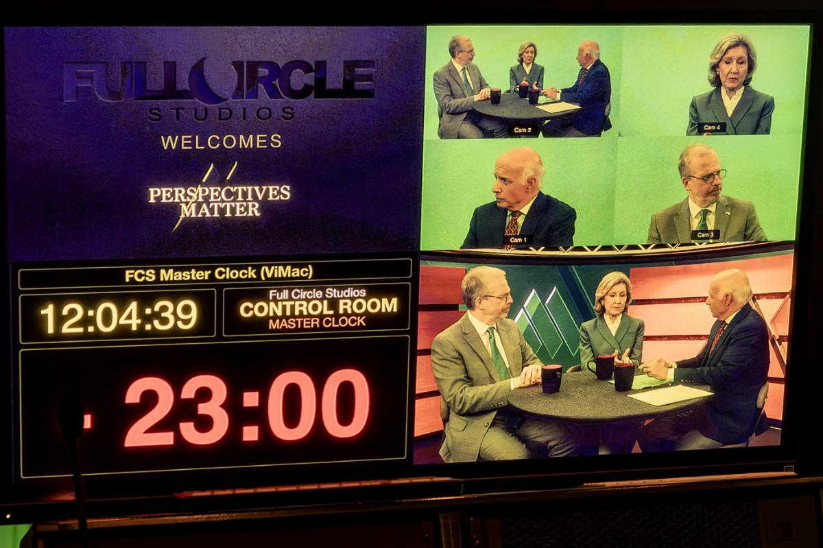 Picture of a control room monitor with four sections. Left Top: Full Circle Studios logo with “Welcomes “perspectives Matter”, Right Top: four up green screen showing a wide shot of David J. Kramer, Kay Bailey Hutchison, and Jim Falk at the Perspectives Matter table, and a one-shot of each member of that group, Left Bottom: Control room master clock at 12:14:39 with 23:00 at the bottom in red, and Bottom Right: Wide shot showing David J. Kramer, Kay Bailey Hutchison, and Jim Falk at the table with the McCuistion TV background behind them.