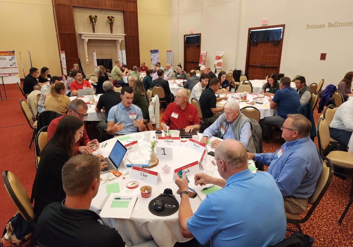 Groups of people sitting at tables talking.