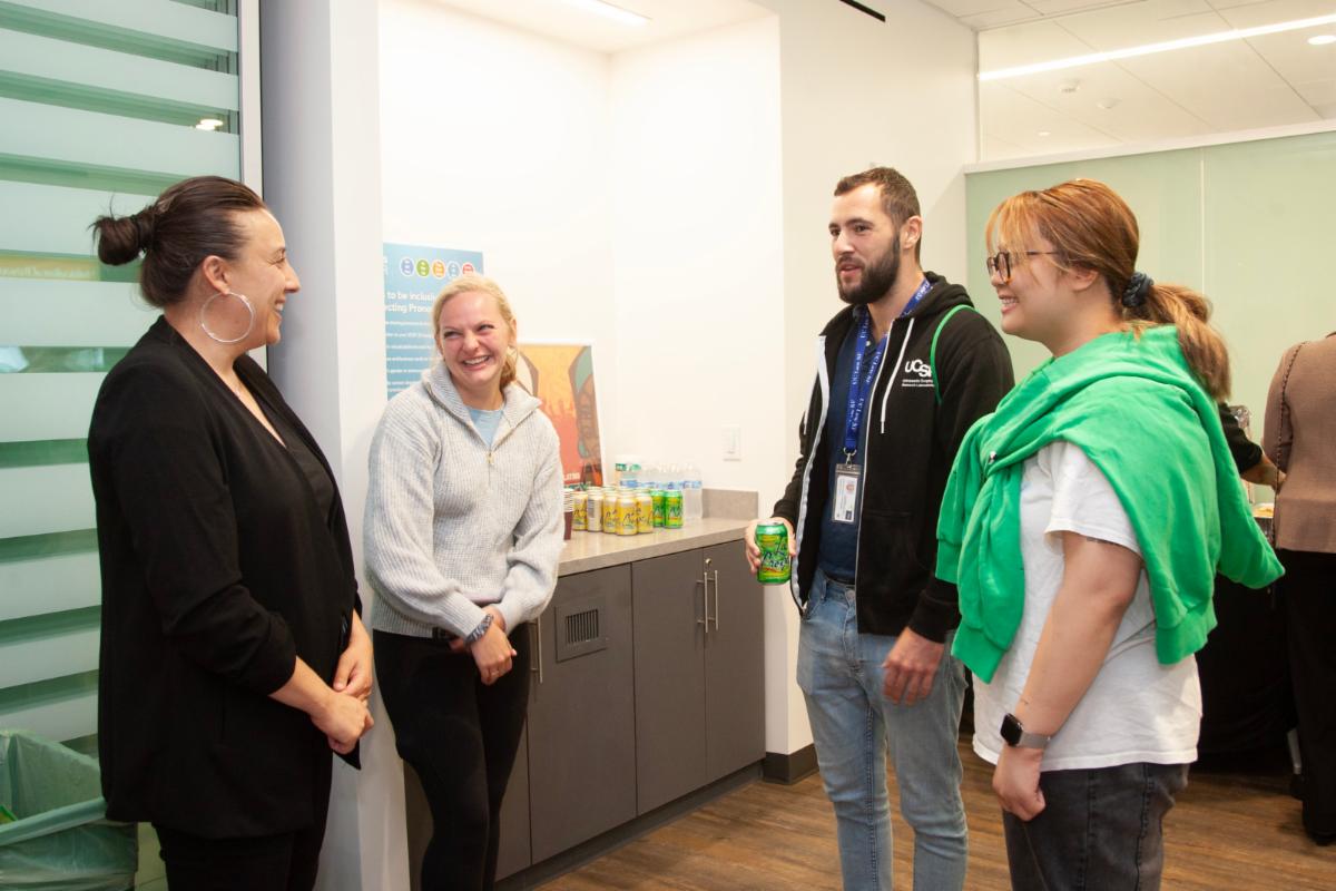 A group of 4 staff and students are engaged in lively discussion in the Resource Centers Fall Open House event. Image by Cindy Chew.