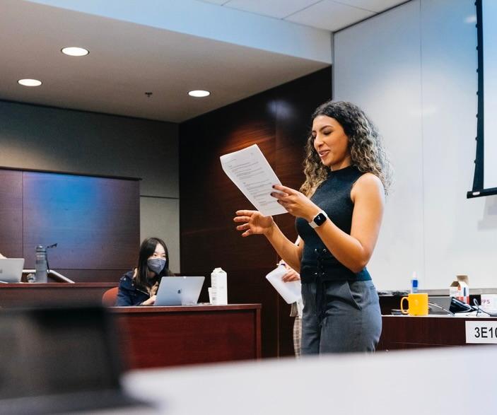 Photo of person reading from document during presentation.