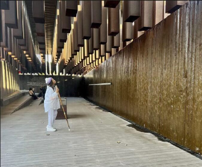 photo of person looking at exhibit large wall installation at the National Memorial for Peace and Justice 