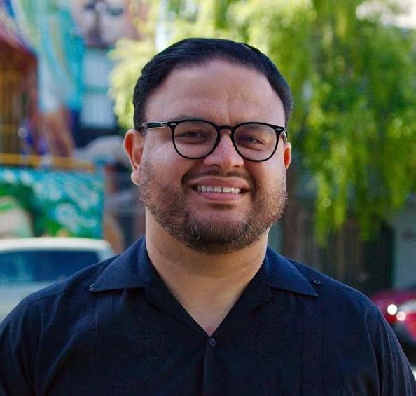 Photo of Manuel Tapia smiling outside. 