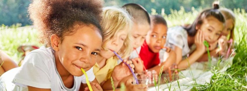 Kids in grass drinking lemonade 