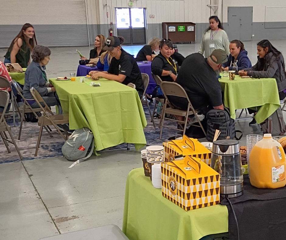 People gather around green table cloths.