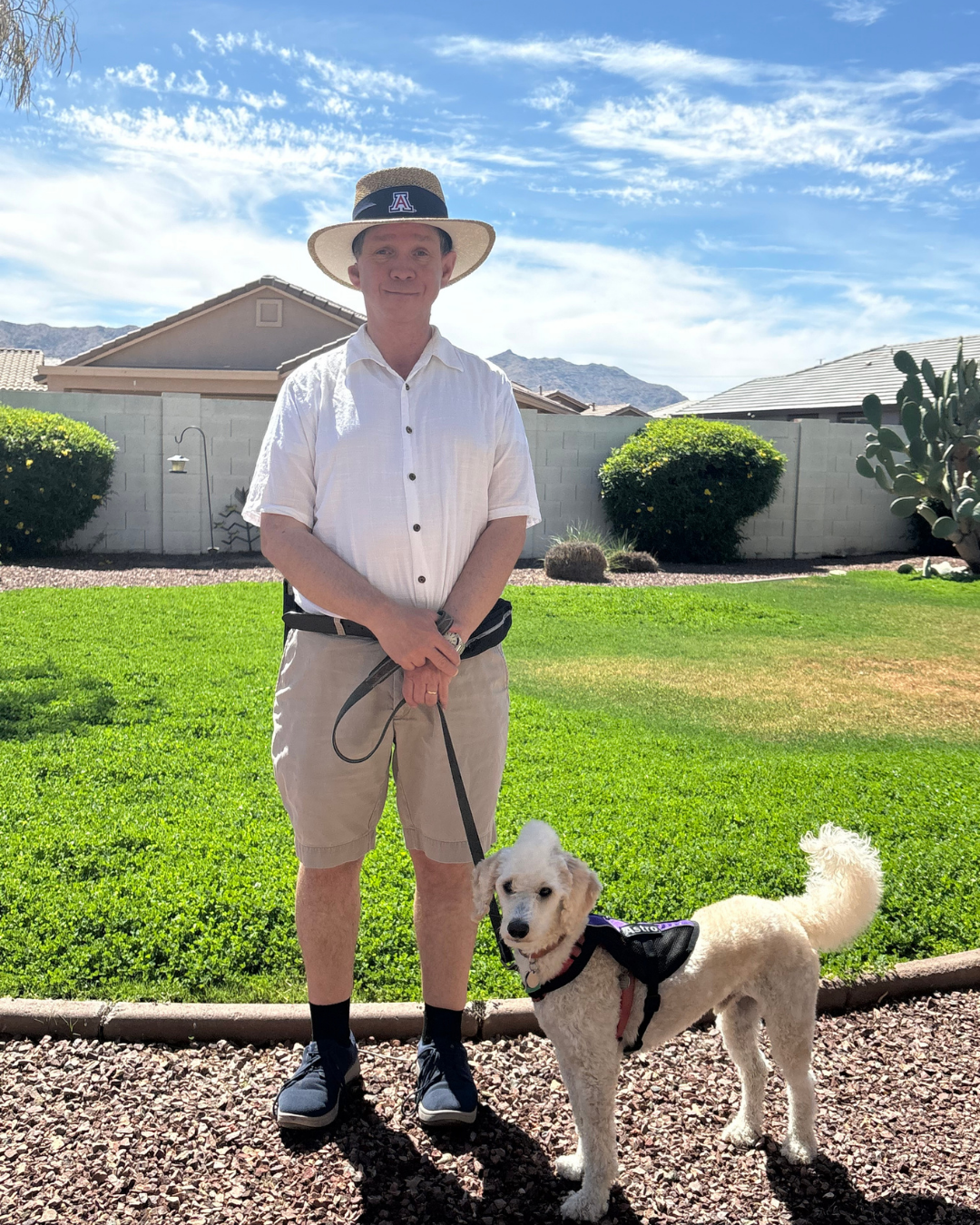 Harvey stands in a hat with his doodle, Astro standing next to him.
